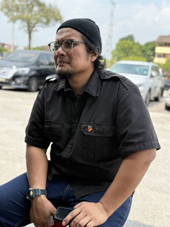 Profile photo of Fendy Taj, Line Producer at Zaramiz Sdn Bhd, dressed in a black shirt and beanie hat posing outdoors.